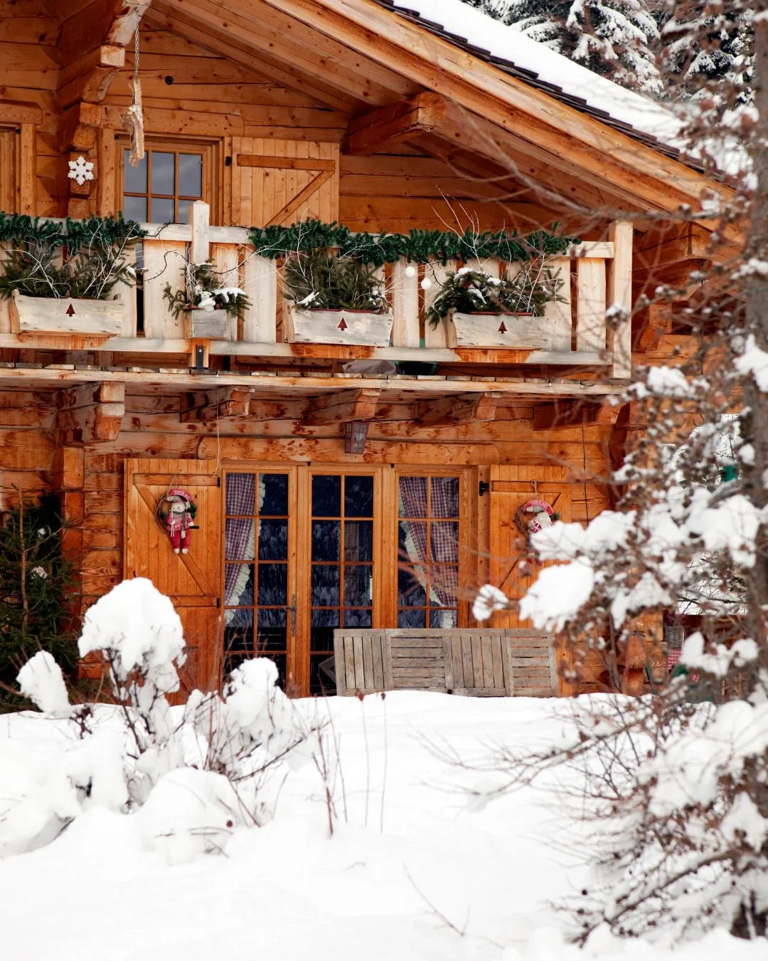 Chalet en bois enneigé avec décoration de Noël, idéal pour maison d'hôtes ou hôtel