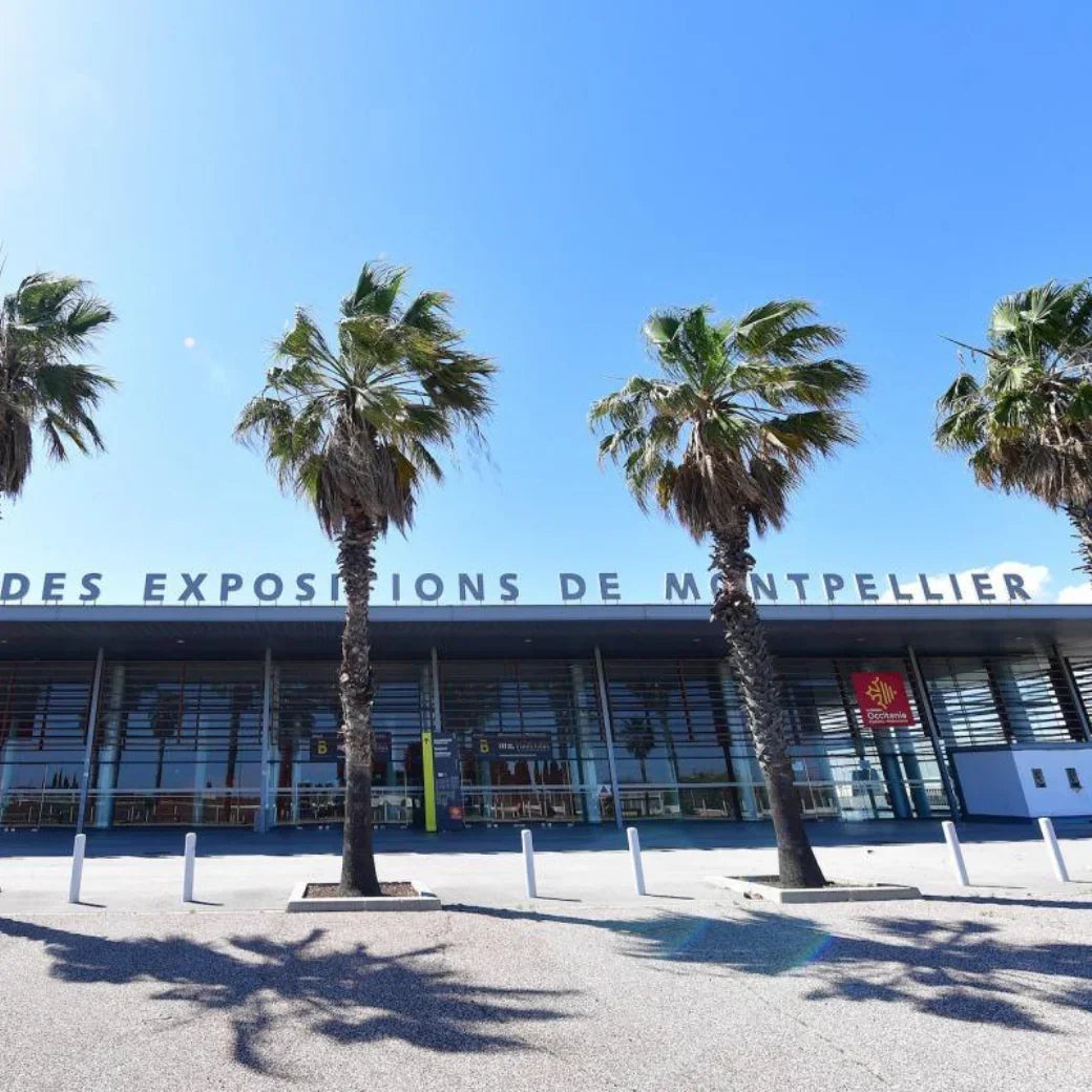 Entrée du Parc des Expositions de Montpellier avec palmiers et ciel bleu ensoleillé