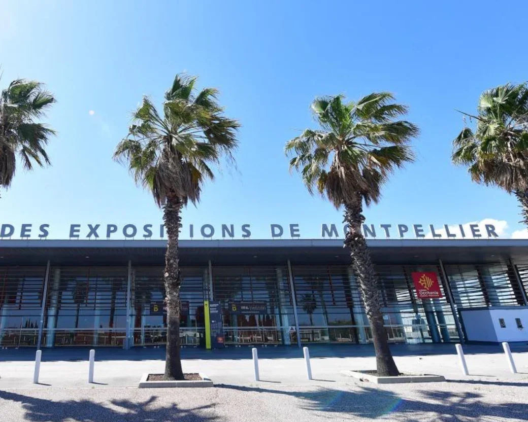 Entrée du Parc des Expositions de Montpellier avec palmiers et ciel bleu ensoleillé