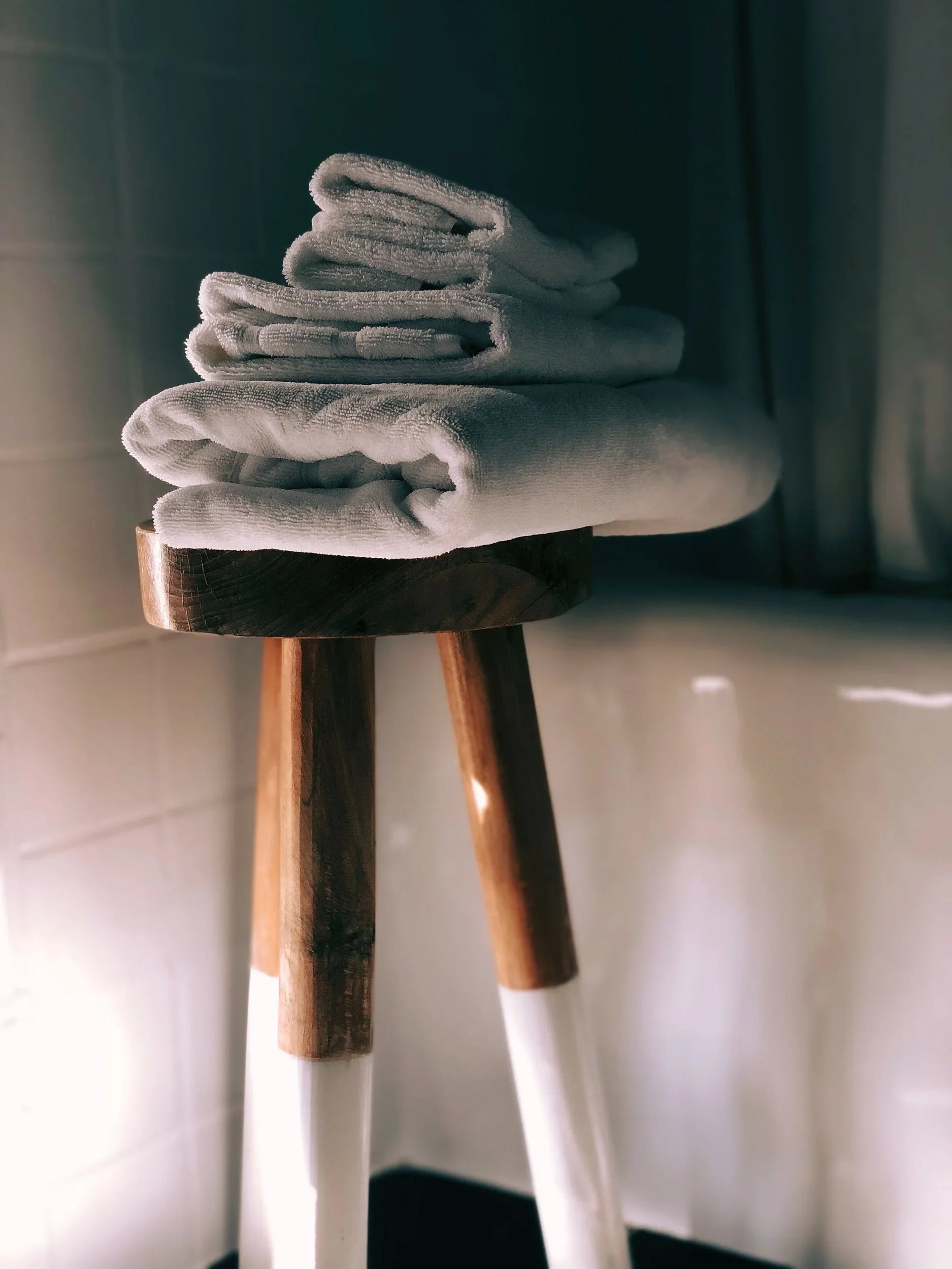 Serviettes d'hôtel premium écoresponsables pliées sur tabouret en bois