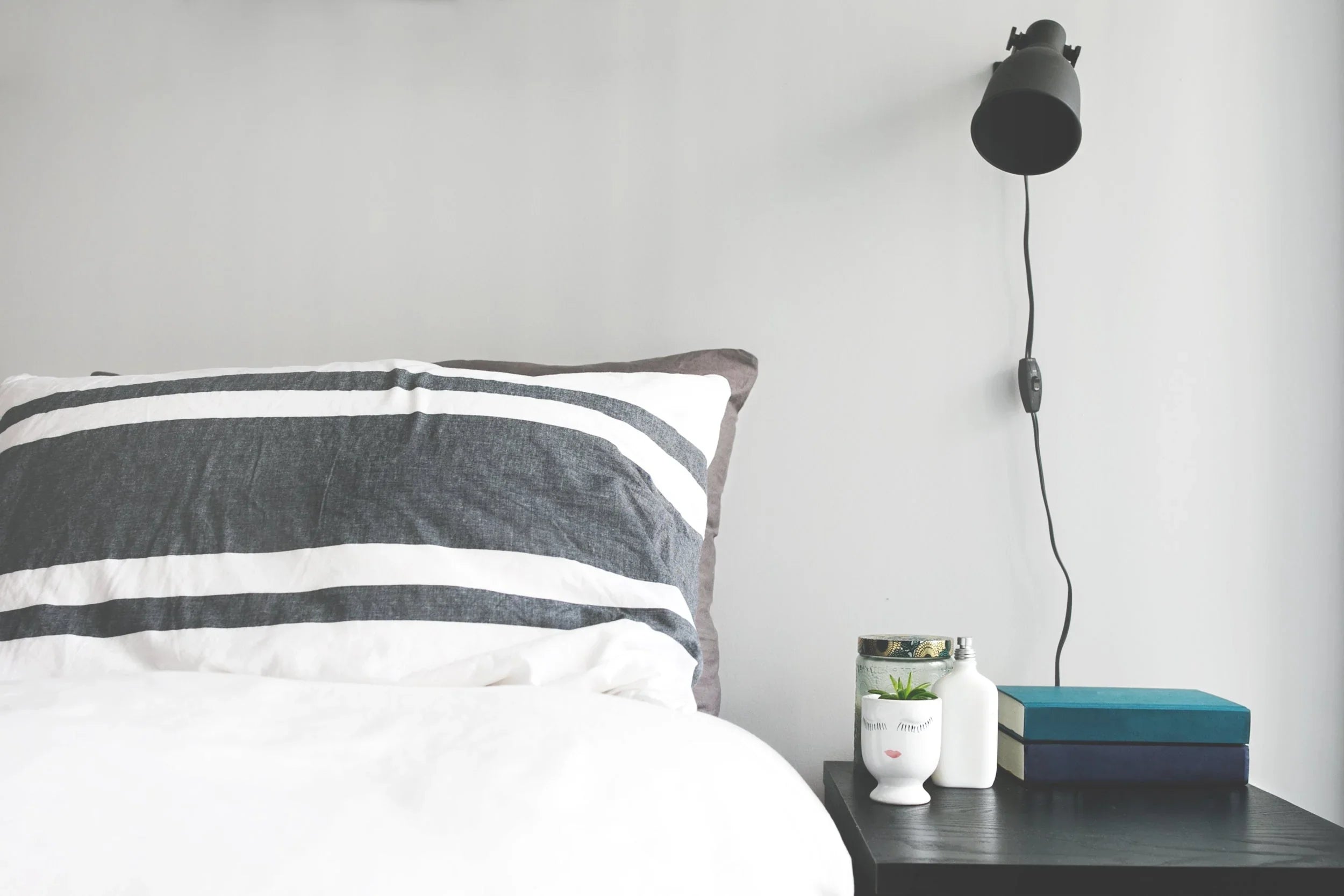 Taie d'oreiller rayée gris et blanc pour linge hôtelier premium, chambre d'hôtel design avec chevet et lampe murale