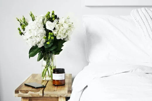 Linge hôtelier blanc écoresponsable avec bouquet de fleurs et détails de chambre d'hôtel
