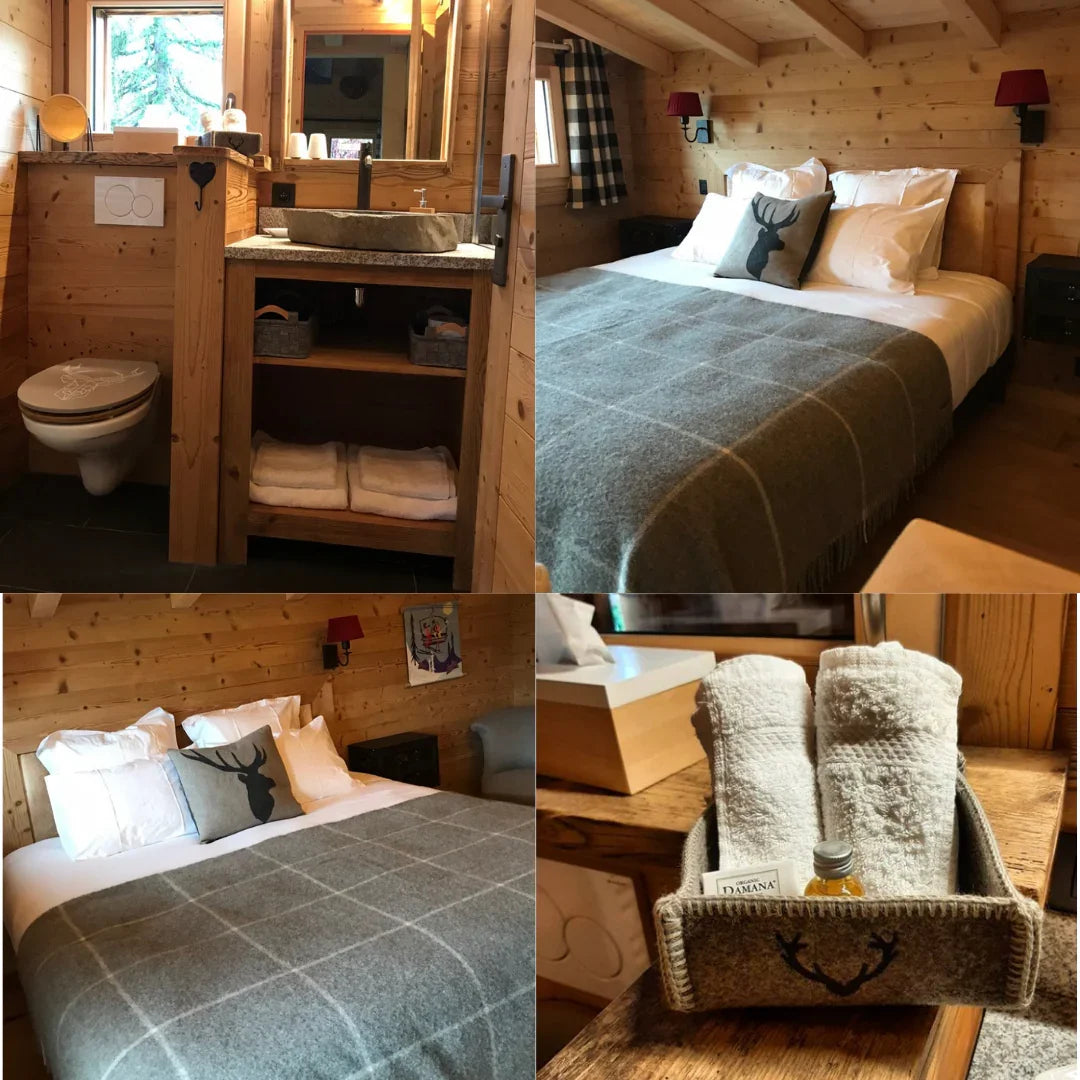 Intérieur chalet bois cosy avec lit double, salle de bain rustique et serviettes décor cerf
