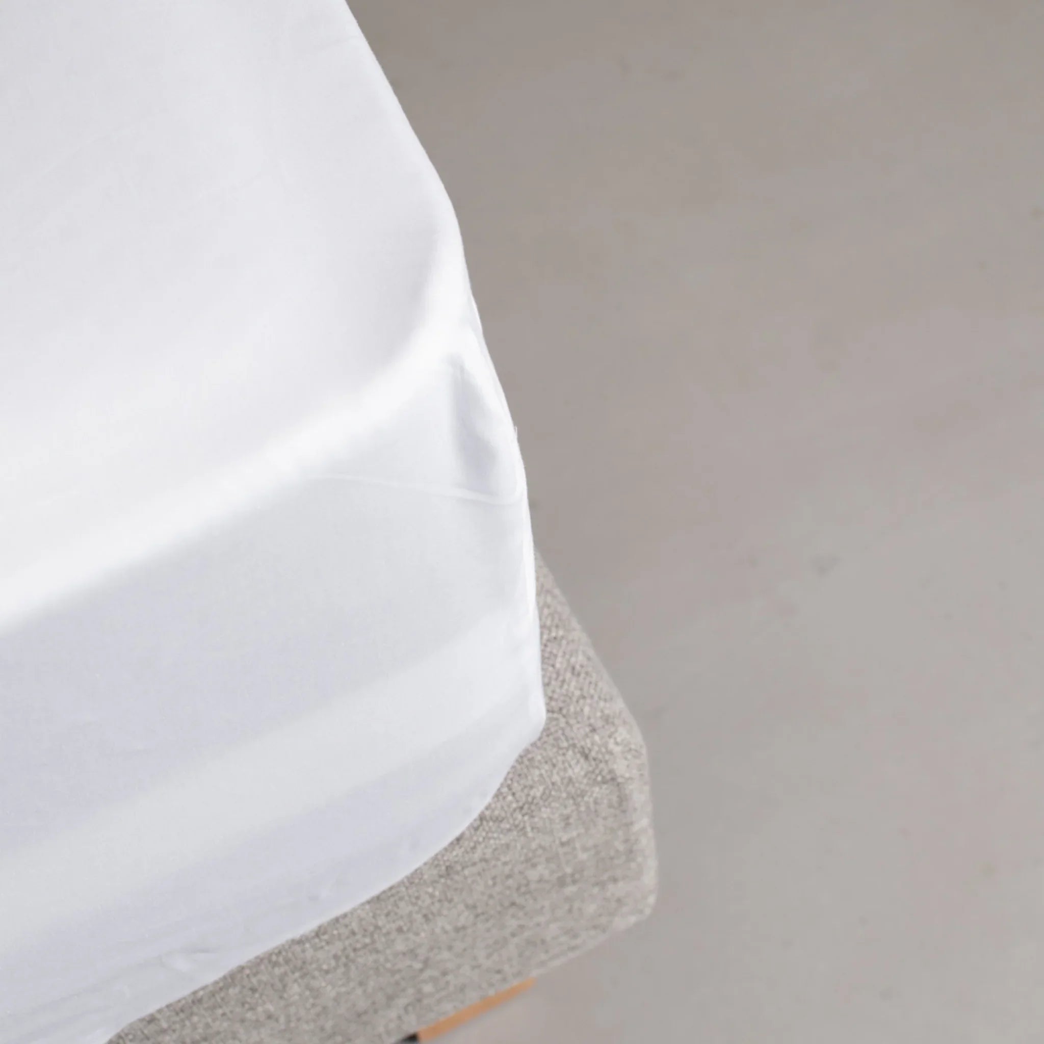 Drap-housse blanc en satin de coton ajusté sur matelas avec coin parfaitement tendu