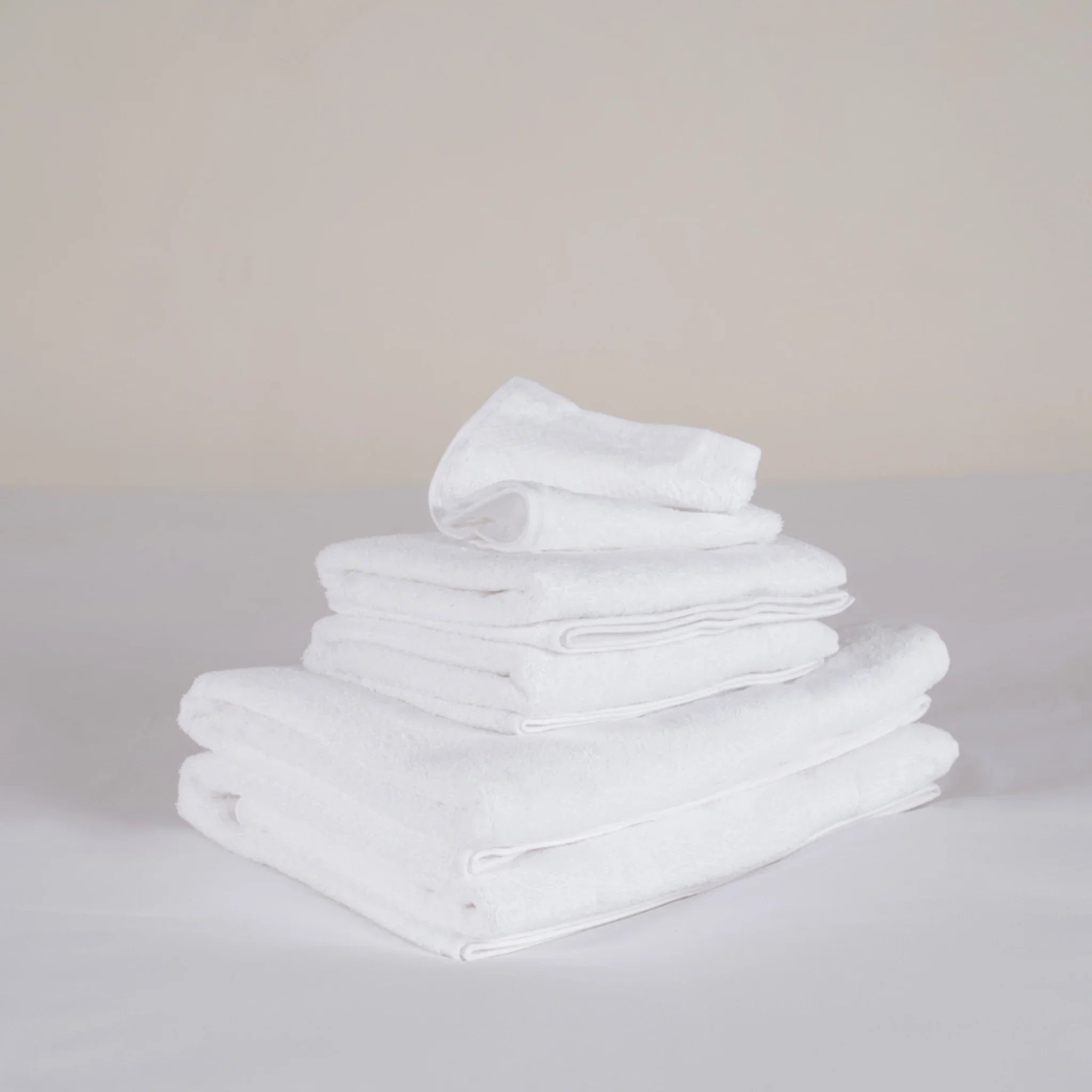 Pile de serviettes de bain blanches douces et épurées, linge de bain de haute qualité