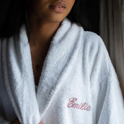 Peignoir blanc en éponge avec broderie prénom Emilie sur la poitrine, porté par une femme